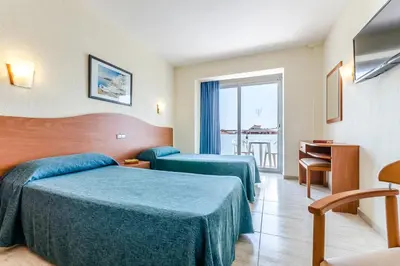 a hotel room with two beds and a balcony at Hotel Mar Blau in Calella