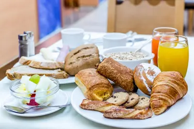 a table with two plates of bread and pastries at Hotel Mar Blau in Calella