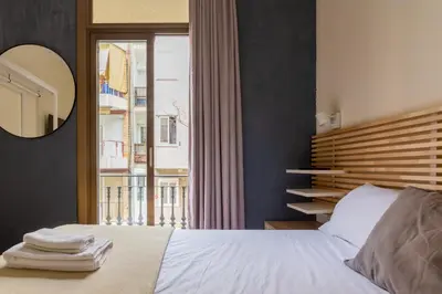 a bedroom with a bed with a mirror and a window at Mambo Tango in Barcelona
