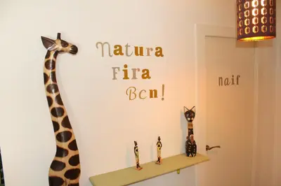 a giraffe stenciled on a wall next to a shelf at Natura Fira Barcelona in Hospitalet de Llobregat