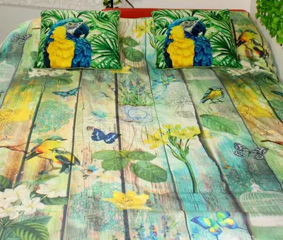 two blue and yellow birds sitting on top of a bed at Natura Fira Barcelona in Hospitalet de Llobregat