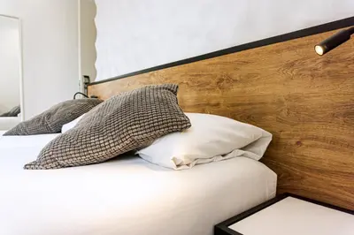 a bedroom with two beds and a wooden headboard at Fontanella Green House in Barcelona