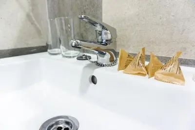 a bathroom sink with a faucet and some gold dishes at Fontanella Green House in Barcelona
