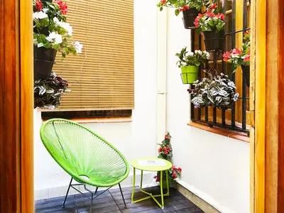 a green chair and a table on a patio at Hostal Portugal in Barcelona