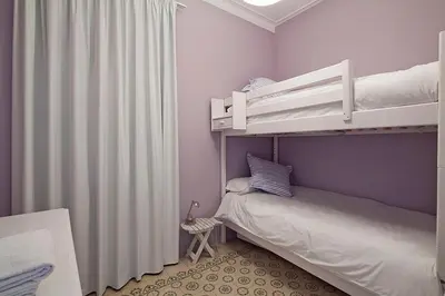 a small bedroom with a bunk bed with purple walls at Central and Spacious Family Apartment in Barcelona