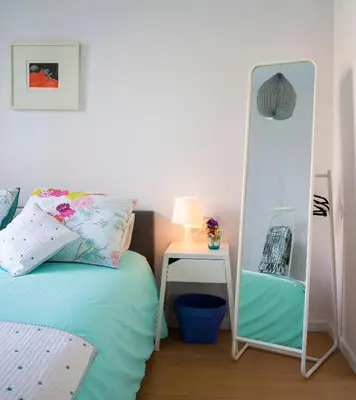 a bedroom with a mirror next to a bed and a table at Cozy Flat With Unbeatable Views to Sagrada Familia in Barcelona