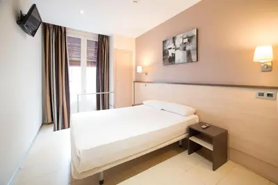 a hotel room with a bed and a window at Hostal Las Flores Ramblas in Barcelona
