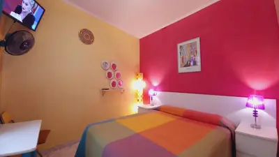 a bedroom with a bed and a red wall at Plaza Universitat in Barcelona