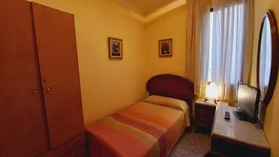 a small bedroom with a bed and a television at Plaza Universitat in Barcelona
