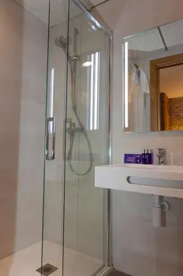 a bathroom with a glass shower and a sink at Hostal Paris in Barcelona