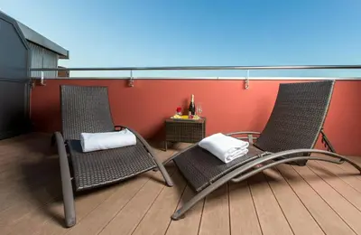 two chairs sitting on a deck with a table at Leonardo Boutique Hotel Barcelona Sagrada Familia in Barcelona
