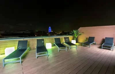 a group of chairs sitting on a rooftop at night at Leonardo Boutique Hotel Barcelona Sagrada Familia in Barcelona