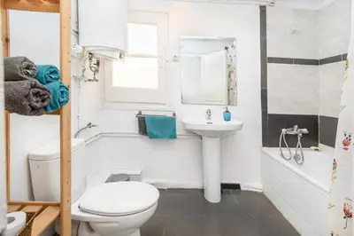 a bathroom with a white toilet and a sink at Private Roof Top Sant Antoni in Barcelona