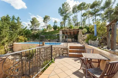 a patio with a table and chairs next to a pool at HHBCN Can Surià in Olivella