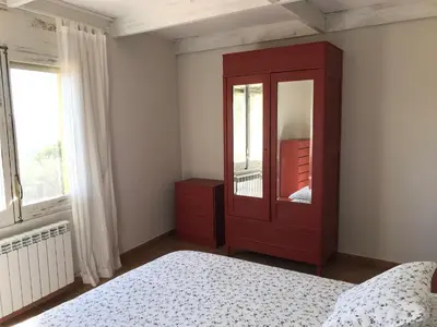 a bedroom with a red cabinet and a bed at Montserrat La Calsina in Monistrol