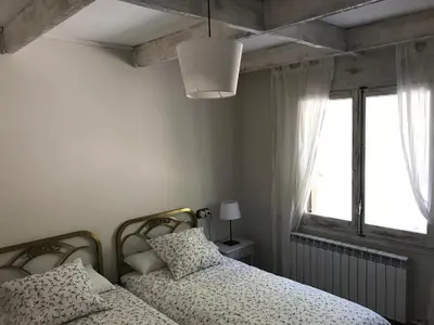 a bedroom with two beds and a window at Montserrat La Calsina in Monistrol