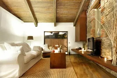 a living room with a white couch and a fireplace at Fonda La Masia Del Sola in Monistrol de Calders