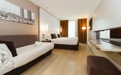 a hotel room with two beds and a desk at Grums Hotel & Spa in Barcelona