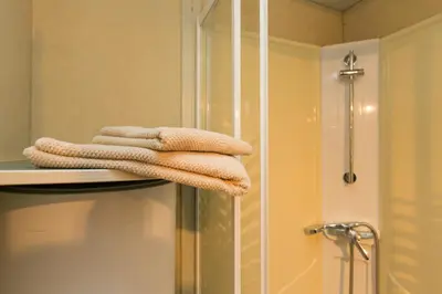 a pile of towels sitting on a shelf in a bathroom at Camping Bungalows El Far in Calella