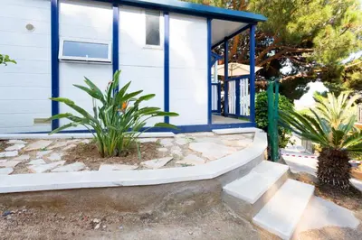 a blue house with stairs in front of it at Camping Bungalows El Far in Calella