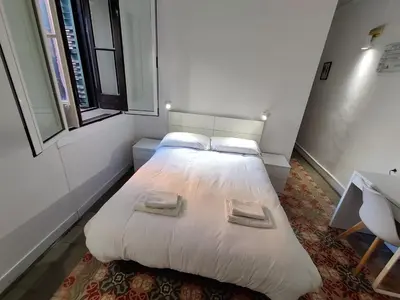 a bedroom with a large white bed with two pillows at Hostal del Palau in Barcelona