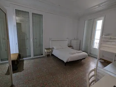 a white bedroom with a bed and a window at Hostal del Palau in Barcelona