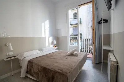 a bedroom with a large bed and a window at Hostal Hera in Barcelona
