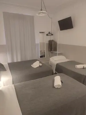 a hotel room with two beds and a television at Hostal Hera in Barcelona