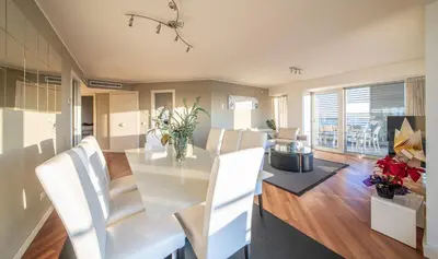 a dining room with a glass table and white chairs at You Stylish Beach Apartments in Barcelona