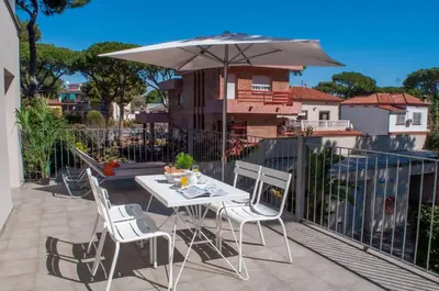 a table and chairs with an umbrella on a balcony at Apartamentos Porta Coeli in Castelldefels