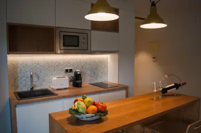 a kitchen with a bowl of fruit on a counter at Apartamentos Porta Coeli in Castelldefels