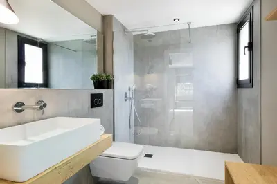 a bathroom with a toilet and a sink and a shower at Apartamentos Porta Coeli in Castelldefels