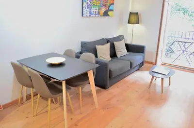 a living room with a blue couch and a table at Poble Sec Apartments in Barcelona