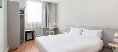 a hotel room with two beds and a television at B&B HOTEL Barcelona Mataro in Mataró