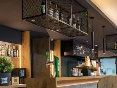a large wooden table with chairs and a potted plant on it at Ibis Montmelo Granollers in Granollers