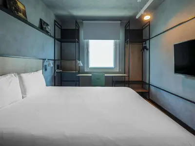 a bedroom with a large white bed and a television at Ibis Montmelo Granollers in Granollers