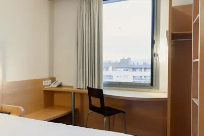 a hotel room with two beds and a window at Ibis Barcelona Mollet in Mollet del Vallès