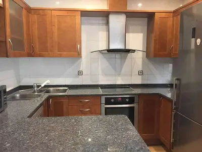 a kitchen with wooden cabinets and a stove top oven at Nice and quiet flat in Premià de Mar - HUTB 01790 in Premiá de Mar