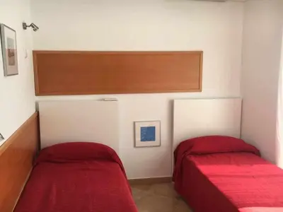 a bedroom with two beds with red sheets at Nice and quiet flat in Premià de Mar - HUTB 01790 in Premiá de Mar