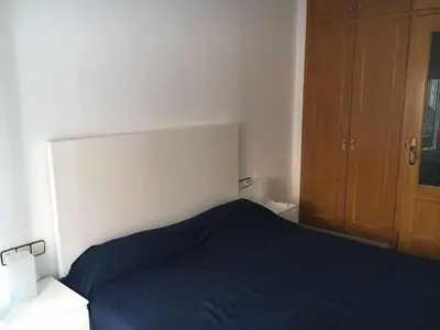 a bedroom with a blue bed and a wooden cabinet at Nice and quiet flat in Premià de Mar - HUTB 01790 in Premiá de Mar
