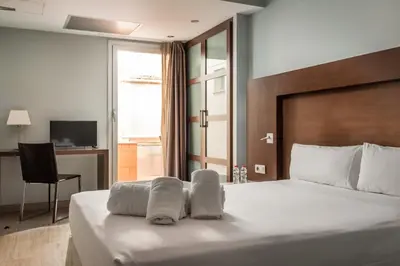 a hotel room with a bed with towels on it at Hotel Madanis Liceo in Hospitalet de Llobregat