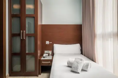 a bedroom with a bed with two towels on it at Hotel Madanis Liceo in Hospitalet de Llobregat