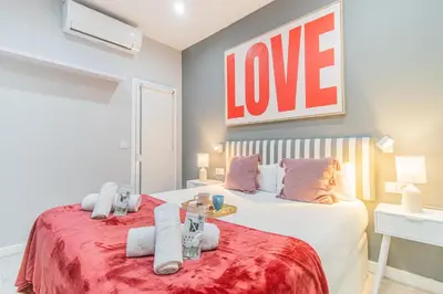 a bedroom with two beds and a love sign on the wall at Fira Rooms Barcelona Hospitalet in Hospitalet de Llobregat