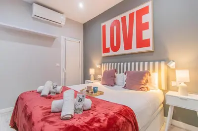 a bedroom with a bed with a love sign on it at Fira Rooms Barcelona Hospitalet in Hospitalet de Llobregat