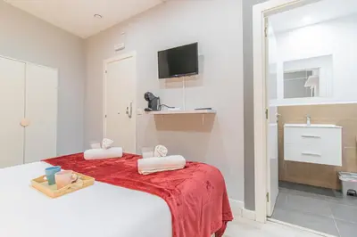 a bedroom with a bed with a red blanket at Fira Rooms Barcelona Hospitalet in Hospitalet de Llobregat