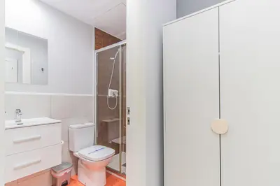 a bathroom with a toilet and a glass shower at Fira Rooms Barcelona Hospitalet in Hospitalet de Llobregat