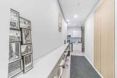 a hallway with benches and pictures on the wall at Fira Rooms Barcelona Hospitalet in Hospitalet de Llobregat