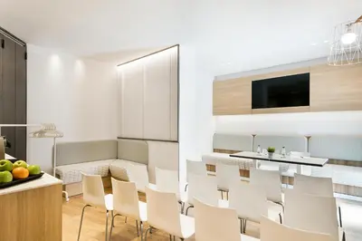 a dining room and kitchen with white chairs and a table at Hotel Acta Laumon in Barcelona
