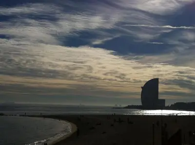 a view of a beach with a large building in the distance at Oasis Near Barcelona Pool Tennis Beach in Sant Andreu de Llavaneres
