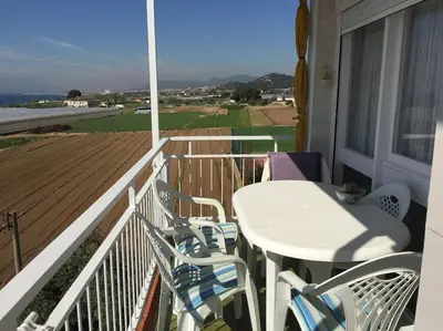 a white table and chairs on a balcony with a view at Oasis Near Barcelona Pool Tennis Beach in Sant Andreu de Llavaneres
